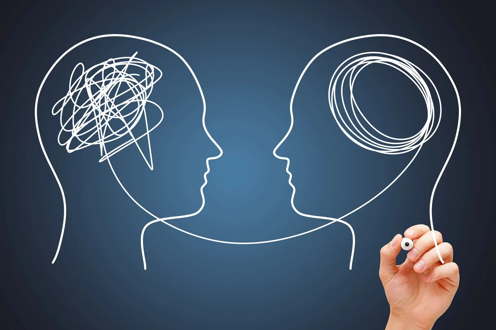 A line drawing of two heads, one filled with a tangled scribble and the other with neat loops
