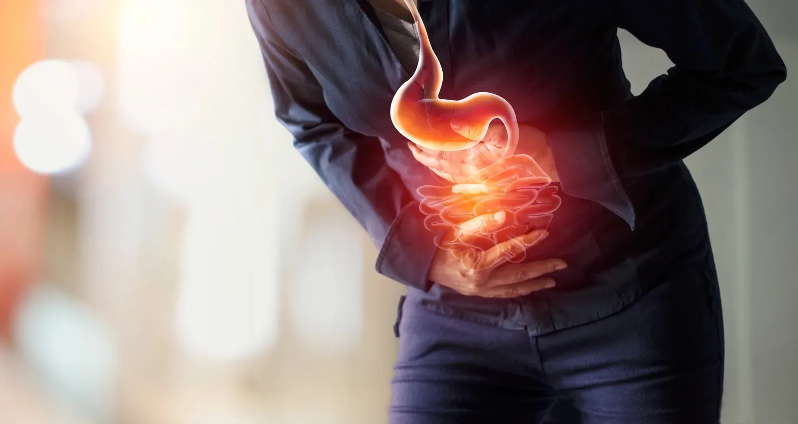 A person holding their side, an illustration of the stomach and intestines glowing over their abdomen